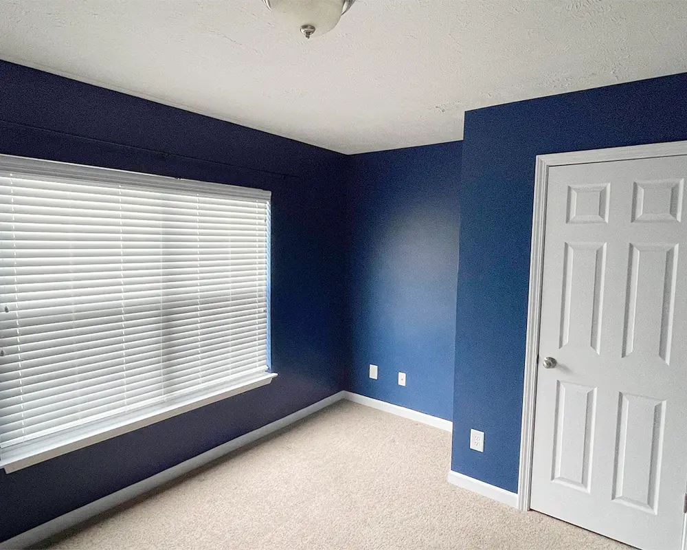 interior painting project of a room with blue walls and white door