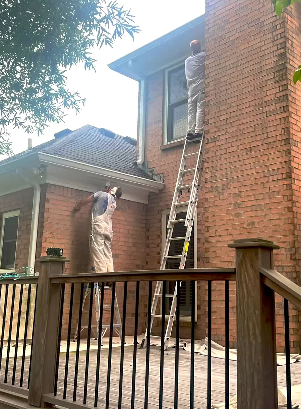 men painting a brick house