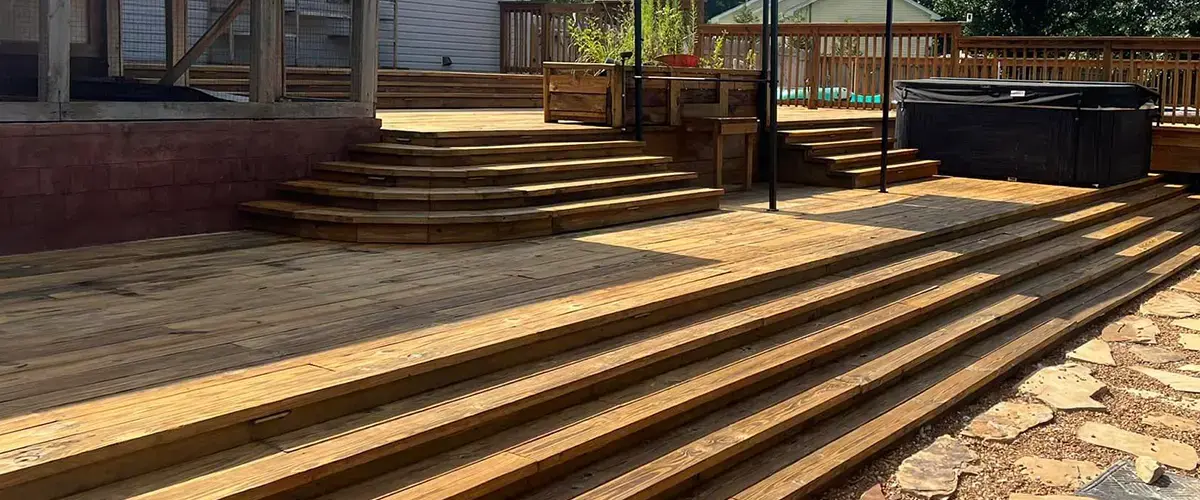 Backyard with wooden deck, hot tub, gazebo, and stone path, ideal for outdoor relaxation. Deck Staining In Fairview, TN