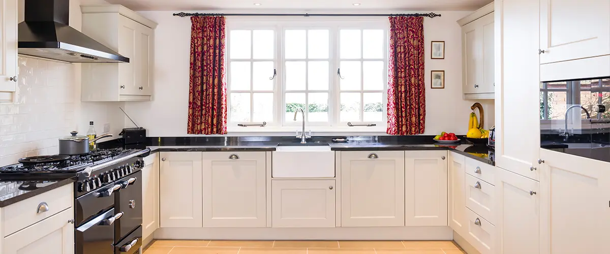 Modern kitchen interior with white painted cabinets, granite countertops, and sleek design.