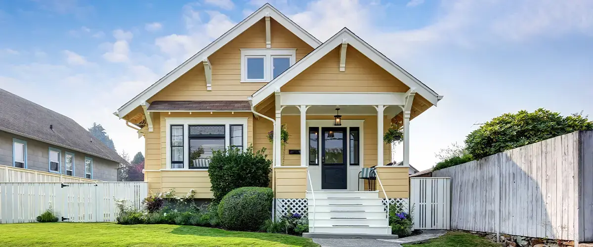 Charming yellow house with white trim and front porch in Franklin residential neighborhood.