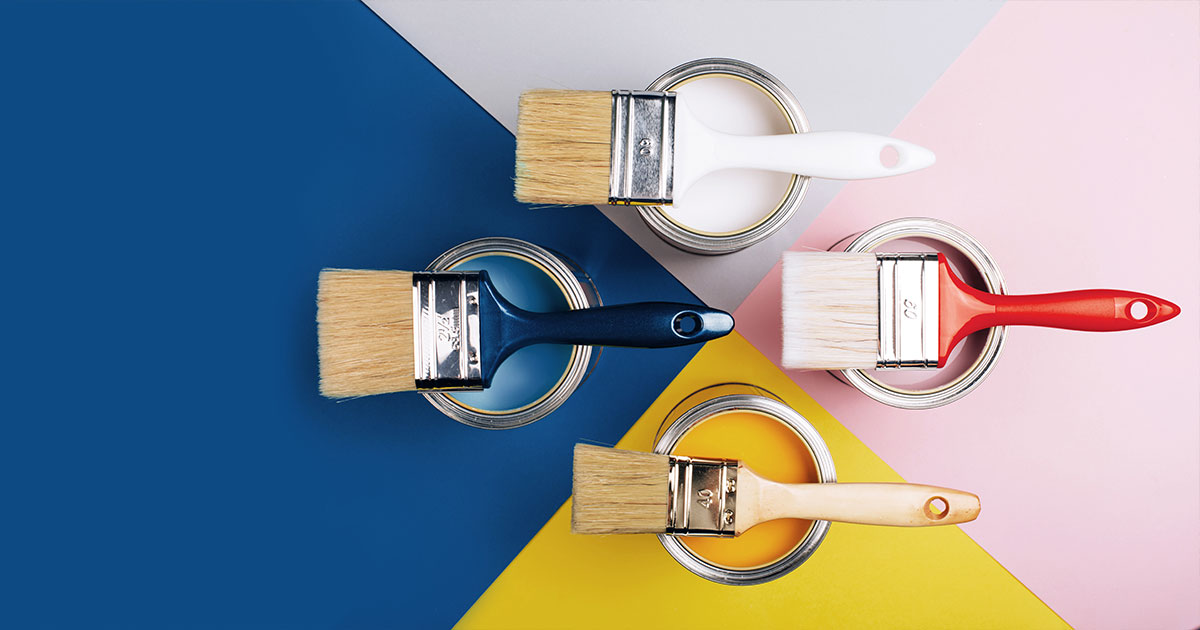 Top view of open paint cans with colorful brushes on geometric background, showcasing the difference between eggshell and matte.