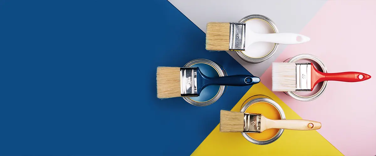 Top view of open paint cans with colorful brushes on geometric background, showcasing the difference between eggshell and matte.