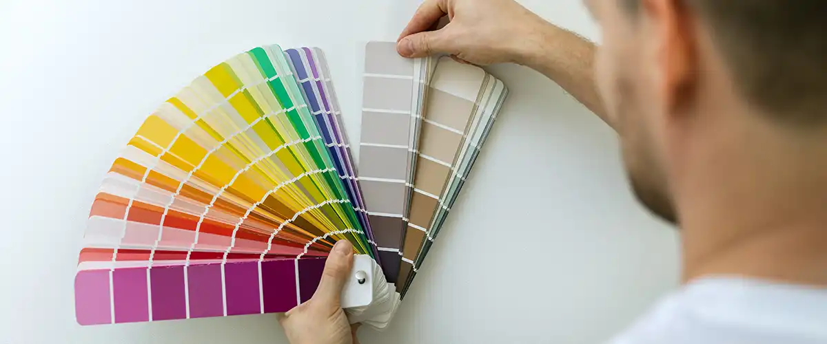 Person holding paint color swatches for home design choices