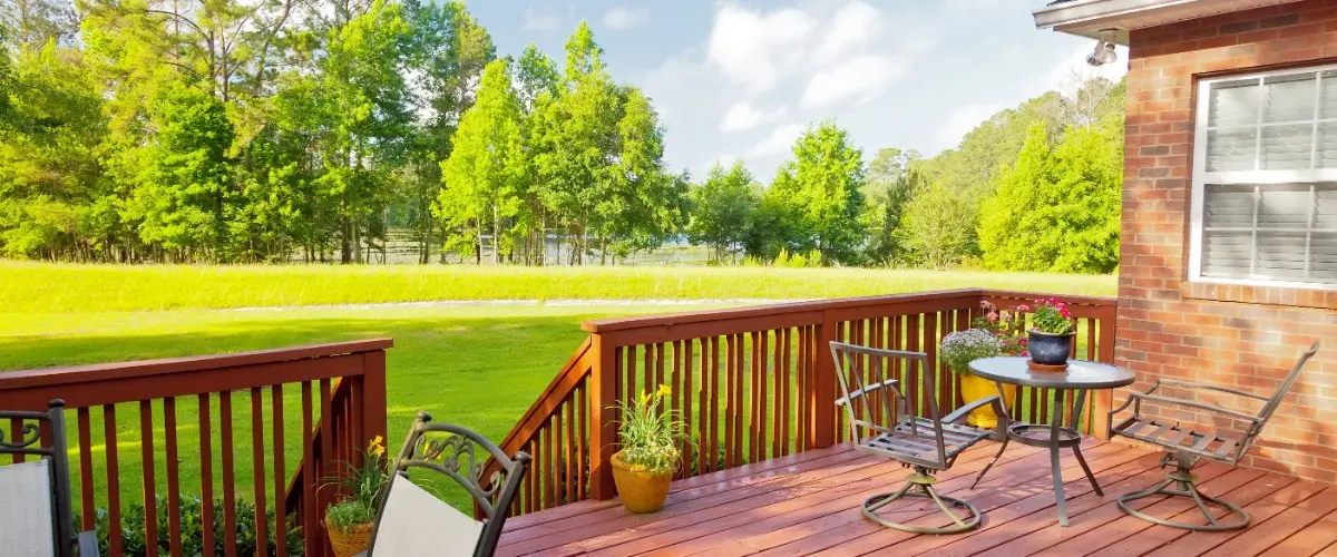 A wooden deck featuring chairs and a table, perfect for outdoor relaxation and dining