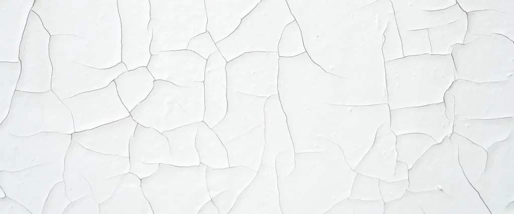 High-resolution texture of white cracked paint with deep fissures spreading across a flat wooden substrate.