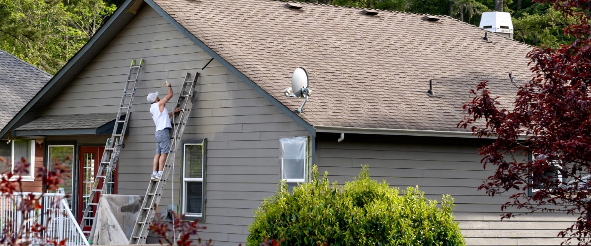 Image of a professional painter working on a house exterior