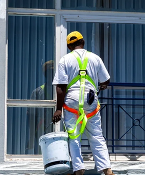 A worker using safety gear to work on commercial painting