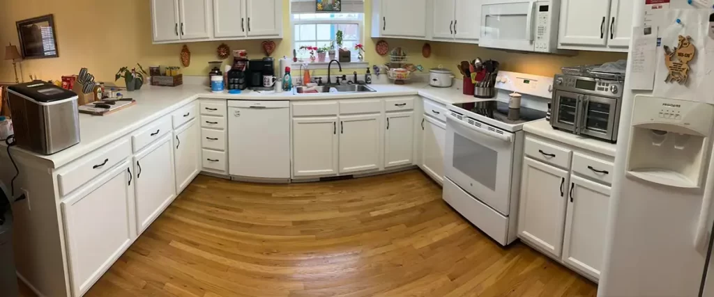 Traditional kitchen remodel with white cabinets, hardwood floors, and updated appliances