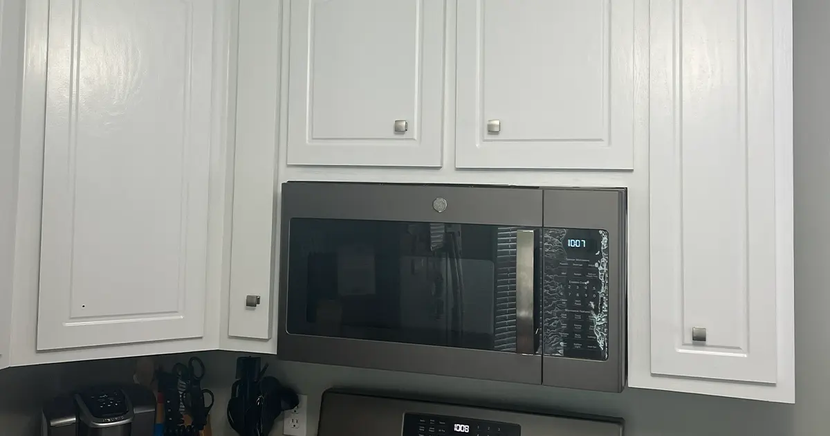 White kitchen cabinets with built-in microwave and modern gray wall paint design