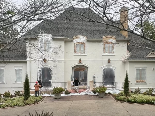 men painting mansion