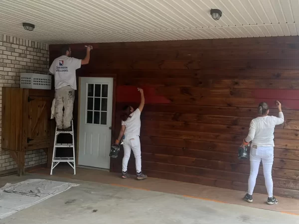 two women and one man painting garage