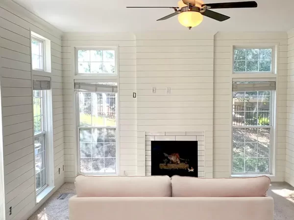 a white painted living room with a white couch and a fireplace