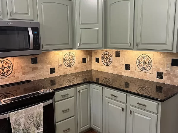 a kitchen with a black stove and white cabinets