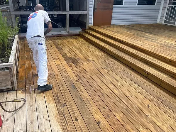 man staining deck